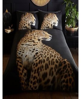 Full size, photographic quality image of a  leopard on a black background. The pillowcases show the leopard's head.